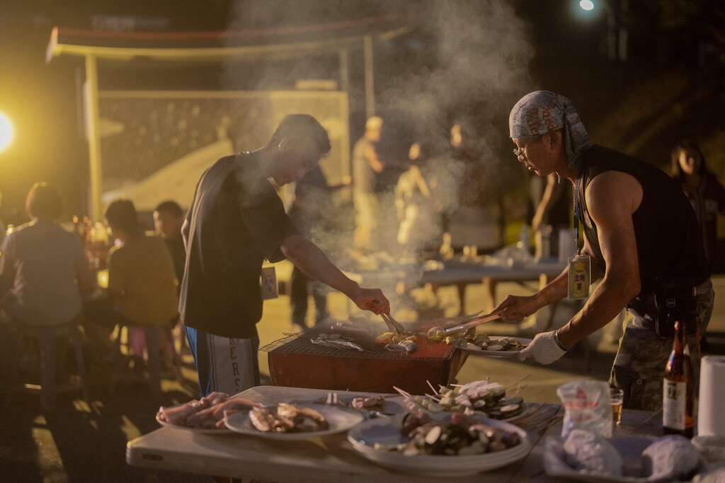 遊客分鄰圍火烤肉，親身體驗部落烤肉的樂趣與氛圍。